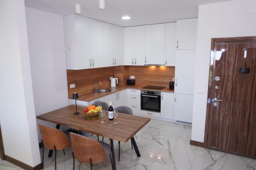 a kitchen with a wooden table and some chairs at Belvedere at Emerald Residence Bar in Bar
