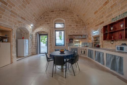 a kitchen with a table and chairs and a brick wall at San Leonardo Apartments in Lecce