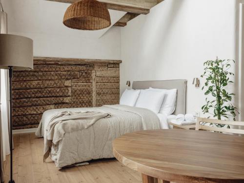 a bedroom with a bed and a wooden table at Mācītāja māja in Cēsis