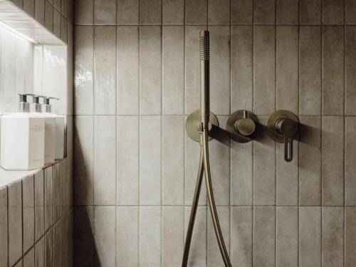 a shower in a bathroom with a shower head at Mācītāja māja in Cēsis