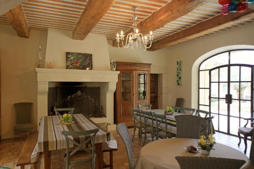 a dining room with tables and chairs and a fireplace at Mas Loisonville - Demeure d'exception & Spa en Drôme Provençale in Grillon