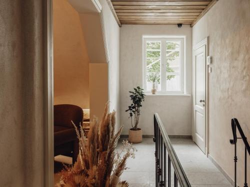a hallway with a chair and a window at Mācītāja māja in Cēsis