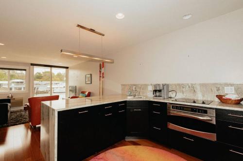 a kitchen with black cabinets and a counter top at Saugatuck Waterfront Getaway Shop, Eat, Bike, Pool in Saugatuck