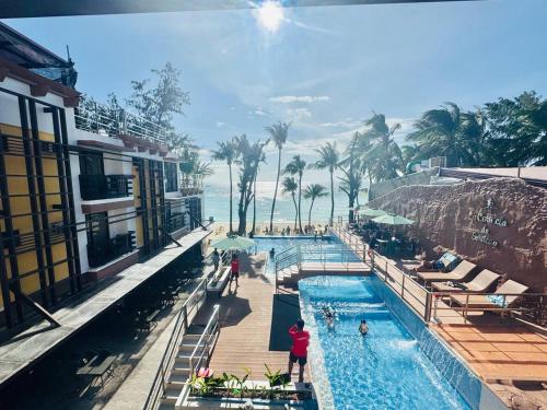 a pool at a resort with people standing around it at La Carmela De Boracay Hotel in Boracay