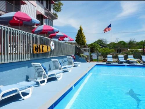 a swimming pool with chairs and umbrellas at Saugatuck Waterfront Getaway Shop, Eat, Bike, Pool in Saugatuck