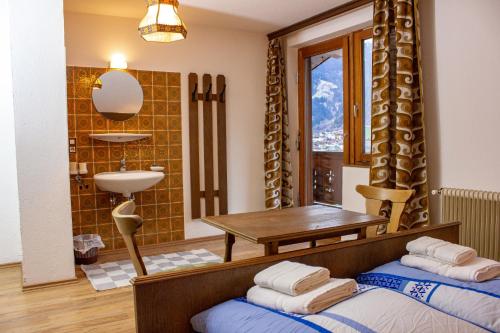 a bedroom with two beds and a table and a sink at Haus Elisabeth in Hainzenberg