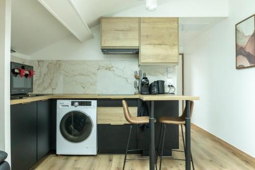 une cuisine avec une machine à laver et une table dans l'établissement Cocon Dacquois, à Dax