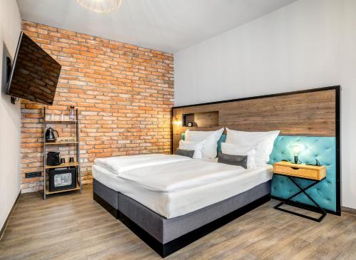 a bedroom with a large bed and a brick wall at Hotel Memories OldTown in Budapest
