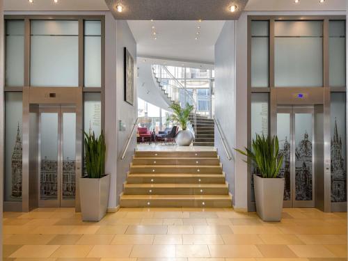 a staircase in a building with potted plants at Mercure Hotel Aachen Am Dom in Aachen
