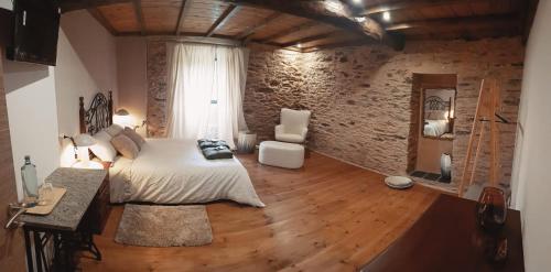 a bedroom with a bed and a wooden floor at Dona Remedios in Xermade