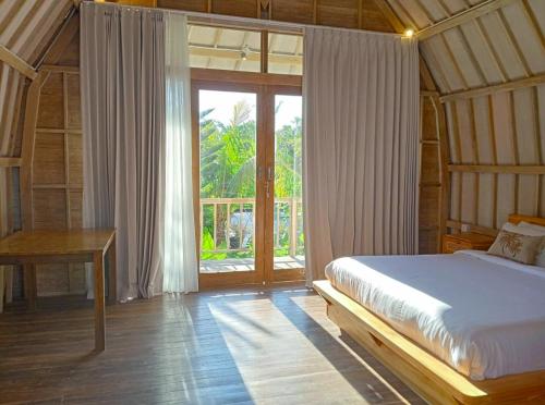 een slaapkamer met een bed en een groot raam bij Villa Lumbung Uluwatu 1 in Uluwatu