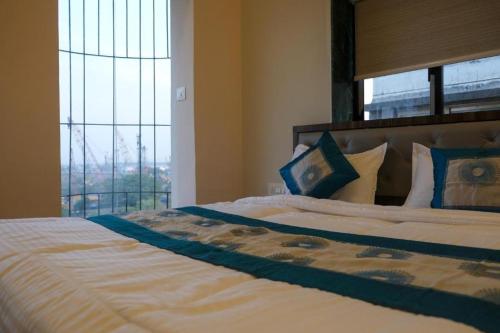 a bedroom with a large bed with a large window at Hotel VRC in Mumbai