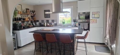 a kitchen with a island with bar stools at Villa Lailléa in Laillé