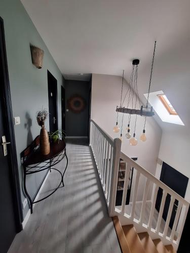 a hallway with a staircase with a table and lights at Villa Lailléa in Laillé