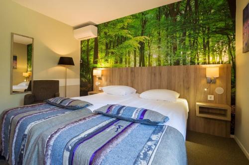 a bedroom with two beds and a mural of trees at Landgoedhotel Woodbrooke Barchem in Barchem