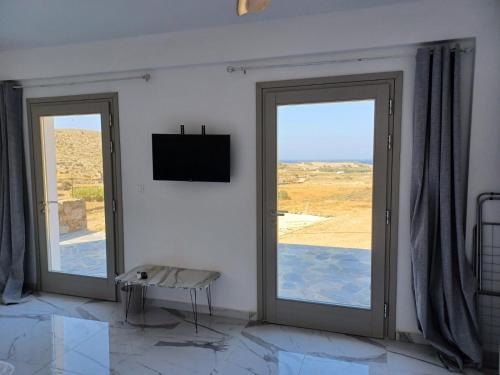 a room with two sliding doors with a view of the desert at Livadi BEACH HOUSES 1 in Chora Folegandros