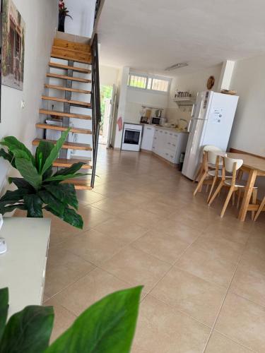 a living room with a staircase and a kitchen at הכינרת מולי in Tiberias