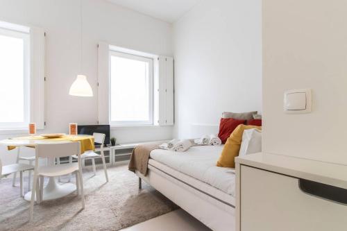 a white living room with a couch and a table at Charming and Well-Located Studio in Chiado in Lisbon