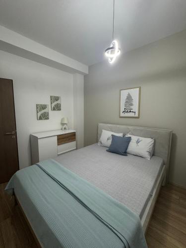 a bedroom with a large bed with blue pillows at Deluxe Apartments in Gevgelija