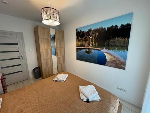 a bedroom with a bed with a painting on the wall at Luksusowy Apartament in Jaworzno