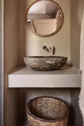 a bathroom with a stone sink and a mirror at Conte Maris VI in Tragaki