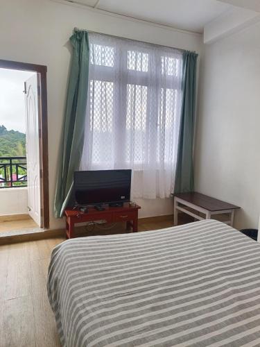 a bedroom with a bed and a large window at Mawdong Homestay in Shillong