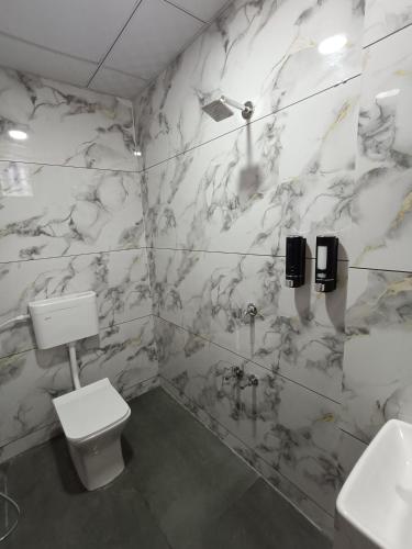 a bathroom with a toilet and a sink at Hotel Ravechi Krupa in Kotharia