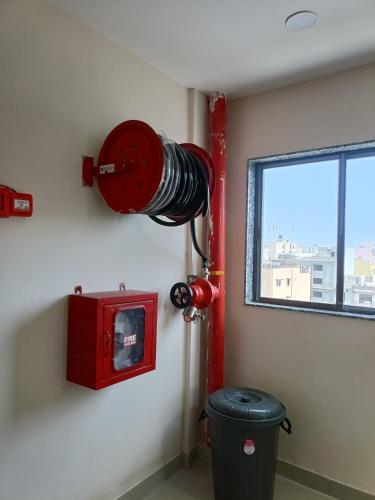 a red fire hydrant on a wall next to a window at Hotel Ravechi Krupa in Kotharia