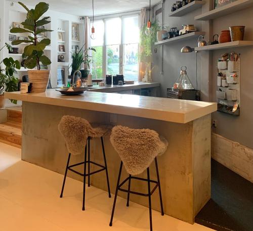 a kitchen with a large counter with two bar stools at B&B Loft 57 in Amsterdam