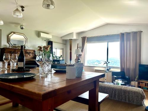 a living room with a wooden table with wine glasses at Typic House - Maison piscine CLIM et VUE in Albi