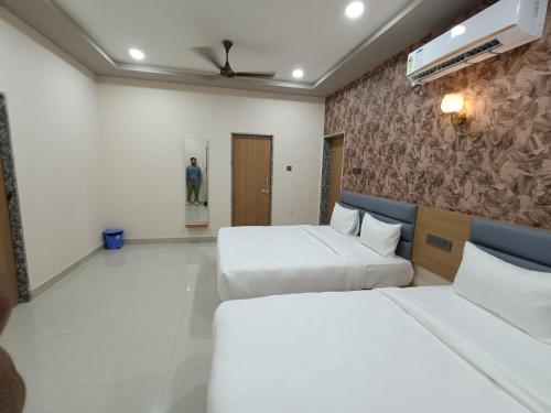a hotel room with two beds and a wall at Hotel Ravechi Krupa in Kotharia