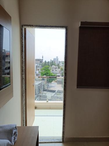 a mirror in a room with a large window at Hotel Ravechi Krupa in Kotharia