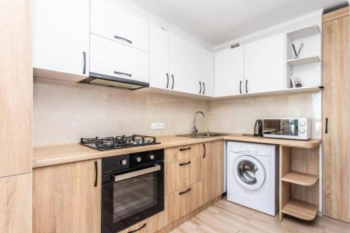 a kitchen with white cabinets and a washer and dryer at Starrent Testimiteanu Kaufland MallDova shopping mall in Chişinău