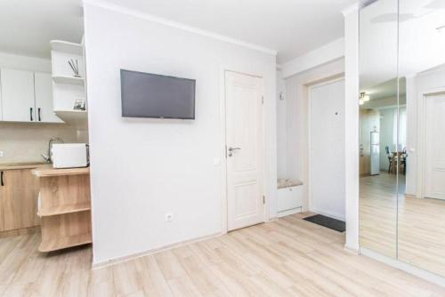 a white kitchen with a flat screen tv on a wall at Starrent Testimiteanu Kaufland MallDova shopping mall in Chişinău