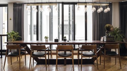 a dining room with a large wooden table and chairs at Poshtel 56 in Bangkok