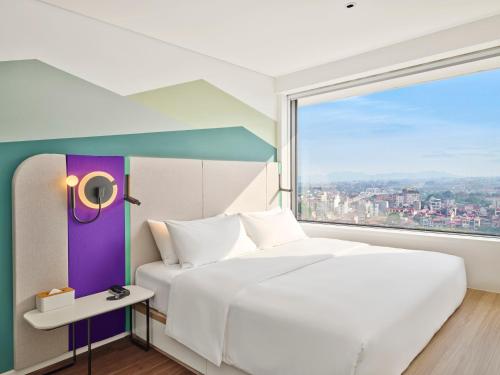 a bedroom with a large white bed and a large window at Tru by Hilton Bac Giang City Centre in Bắc Giang