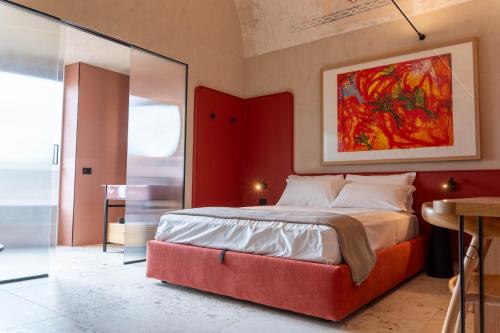 a bedroom with a large bed with a red wall at Casa Tre Archi - Camere Luxury in Altamura