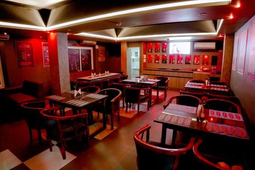 a restaurant with tables and chairs in a room at Queens Hotel in Kozhikode