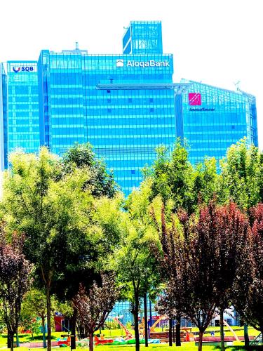 eine Baumgruppe vor einem großen Gebäude in der Unterkunft Boulevard residents Tashkent city 01 in Taschkent