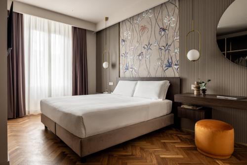 a bedroom with a bed and a table and a mirror at Aramis Deluxe Rooms in Florence
