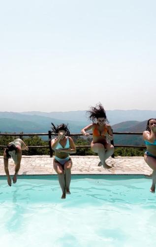 a group of women jumping into a swimming pool at Casa do Capucho - Soajo, Gerês in Soajo