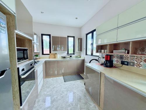 een grote keuken met houten kasten en roestvrijstalen apparatuur bij Caz la plaz - Beach front apartment - 2BR in Flic-en-Flac