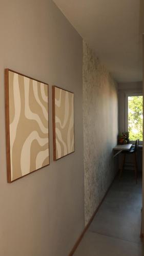 three paintings on a wall in a room at Panorama Piaskowa in Wałbrzych