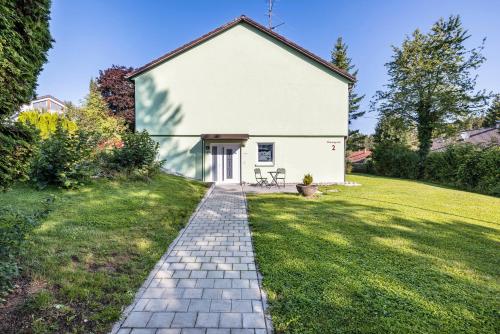 a white house with a brick walkway at Haus Wiesengrund - Hundefreundlich in Gammertingen