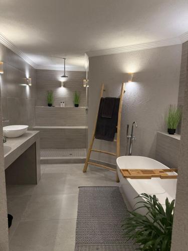 a bathroom with a tub and a toilet and a sink at Bambuu Lakeside Lodge in Hazyview