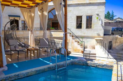 OrtahisarにあるPortal Cappadocia Hotelのスイミングプール(椅子、テーブル付)、