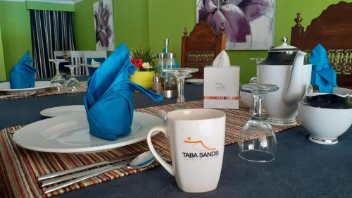 a table with a cup and plates and glasses at Taba Sands Hotel & Casino in Taba