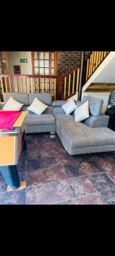 a living room with couches and a table on a floor at B and G Haven in King Williamʼs Town