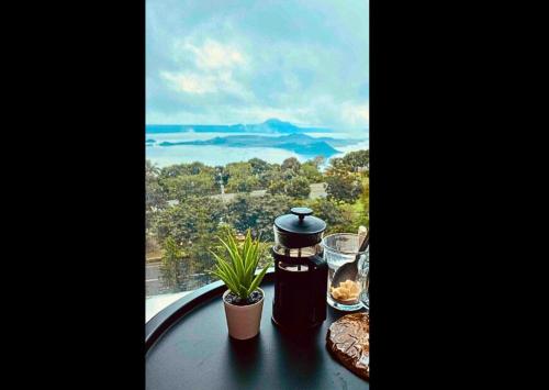 uma mesa com uma cafeteira em uma mesa com uma janela em Need Place To Stay Wake Up to Breathtaking Taal Views from Your Window I Tagaytay Getaway em Kaybagal