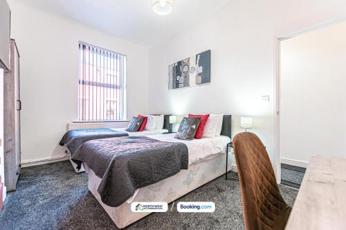 two beds in a room with white walls at Severn Street House Serviced Accommodation in Leigh